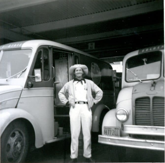 Golden State Dairy employee posing with delivery trucks.
