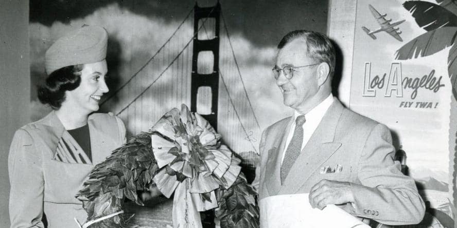 T.W.A hostess Joan Ellis admires the Ina Coolbrith Circle's laurel wreath in honor of Lord Byron. Mr. C. Jones Tyler flew the wreath to Britain, to be placed on Byron's grave, in July 1952.