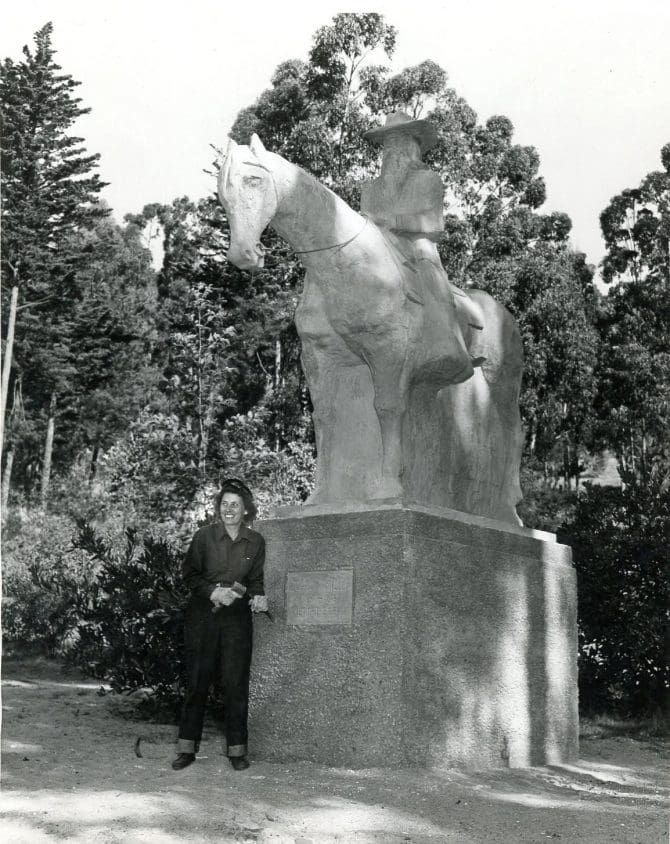 Sculptor Kisa Beeck with her sculpture of Joaquin Miller in Joaquin Miller Park, 1942.