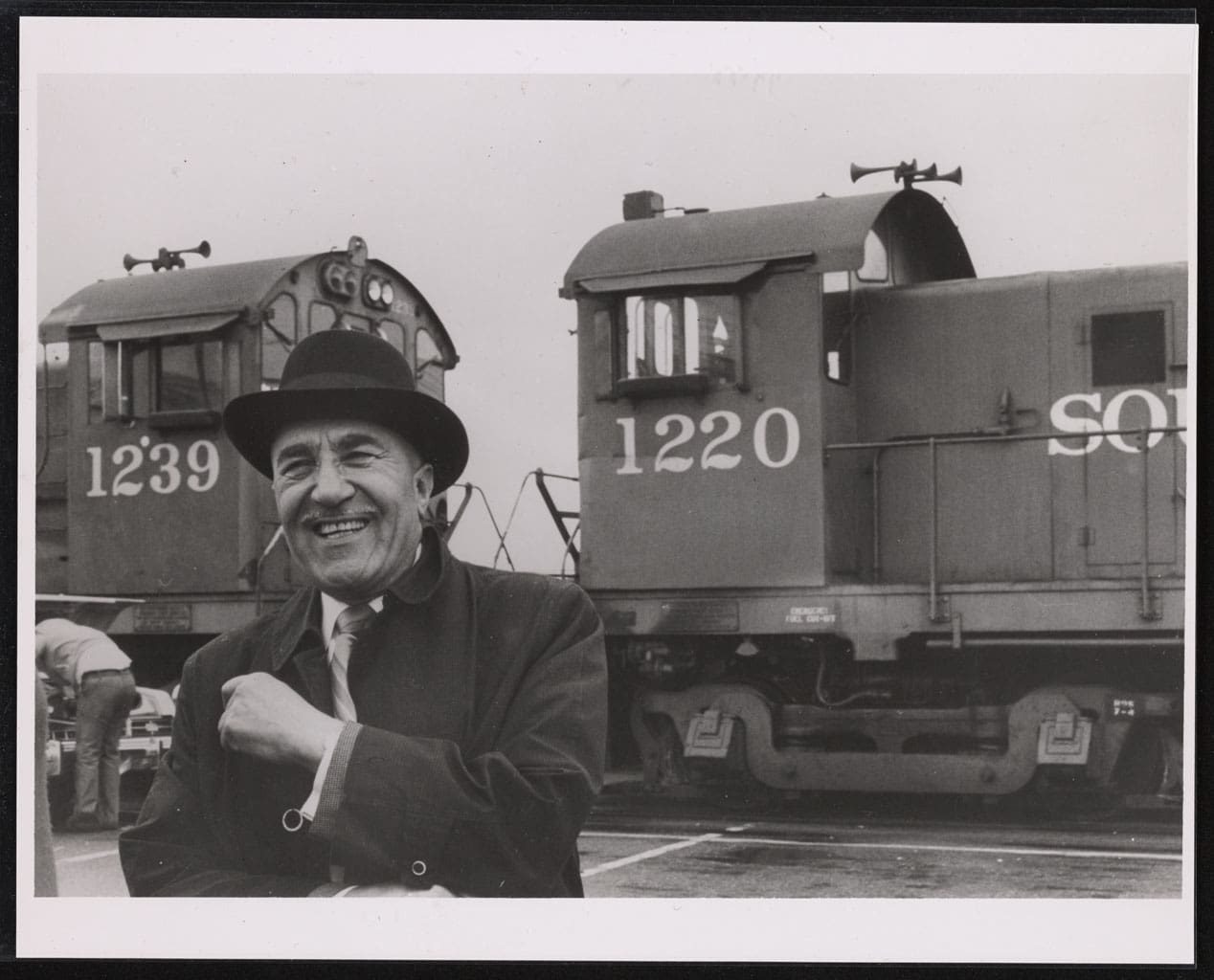 C.L. Dellums smiling standing in front of locomotive