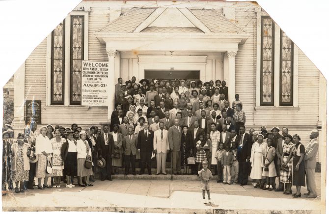 The congregation of the First African Methodist Episcopal Church pose on the steps and sidewalk in front of the church