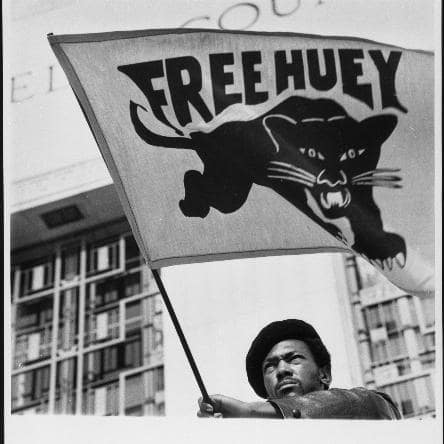 A man waves a Free Huey flag
