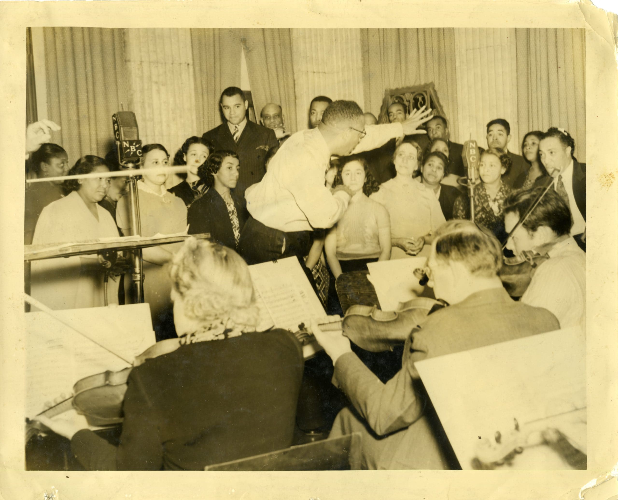 Elmer Keeton directing choir in front of NBC microphones