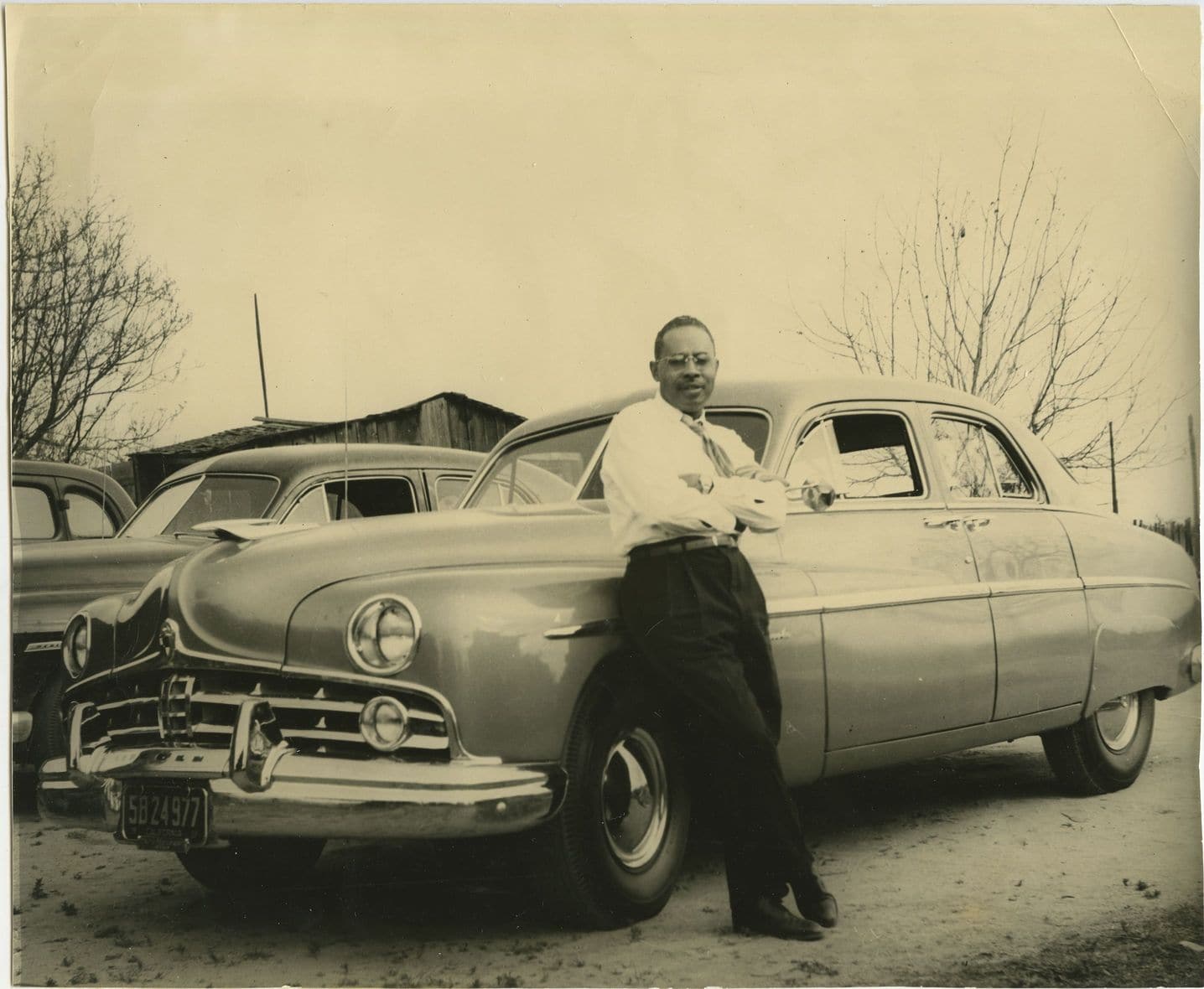 Historic image of William Fletcher leaning against car