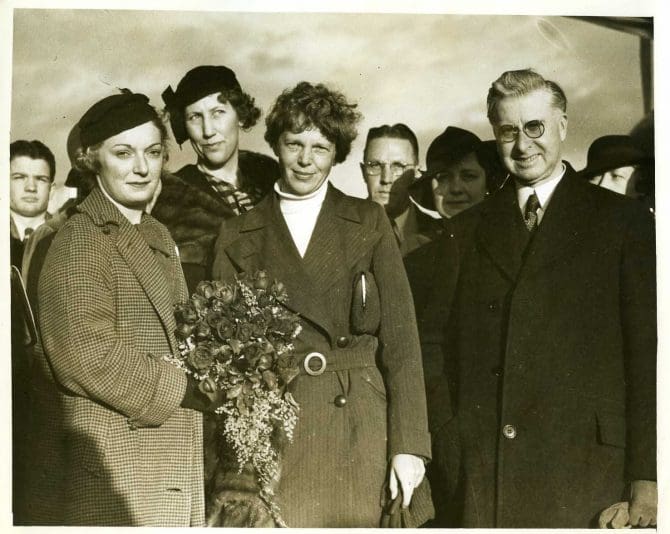 Patty Hassler and Mayor William McCracken presenting a bouquet to Ameilia Earhart on January 19, 1935. Earhart had recently completed the first successful solo flight from Hawaii to the mainland United States.
