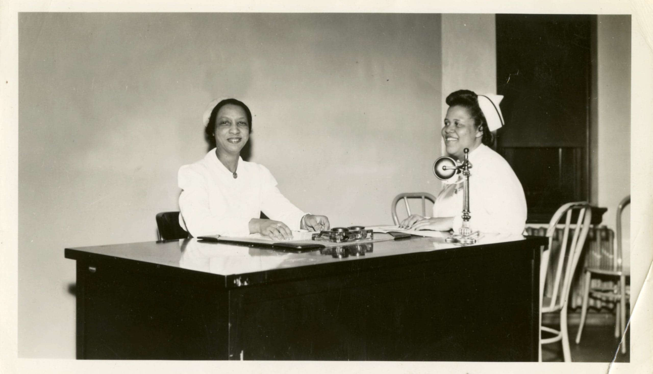 Thelma Gibson Radden sitting at desk with surgical graduate nurse