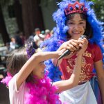 Image of two children wearing colorful boas during a Family Pride celebration in Oakland