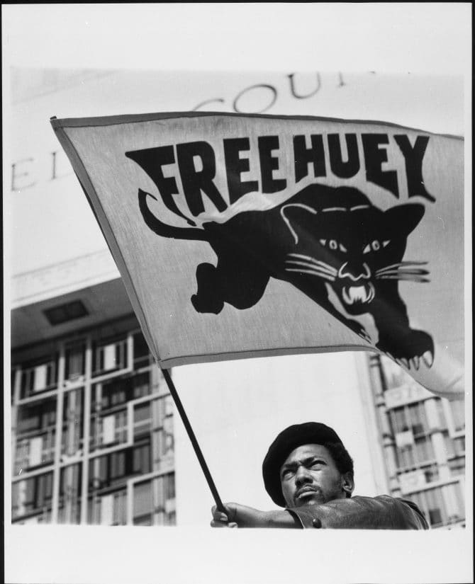 Historic image of Black Panther waving Free Huey flag