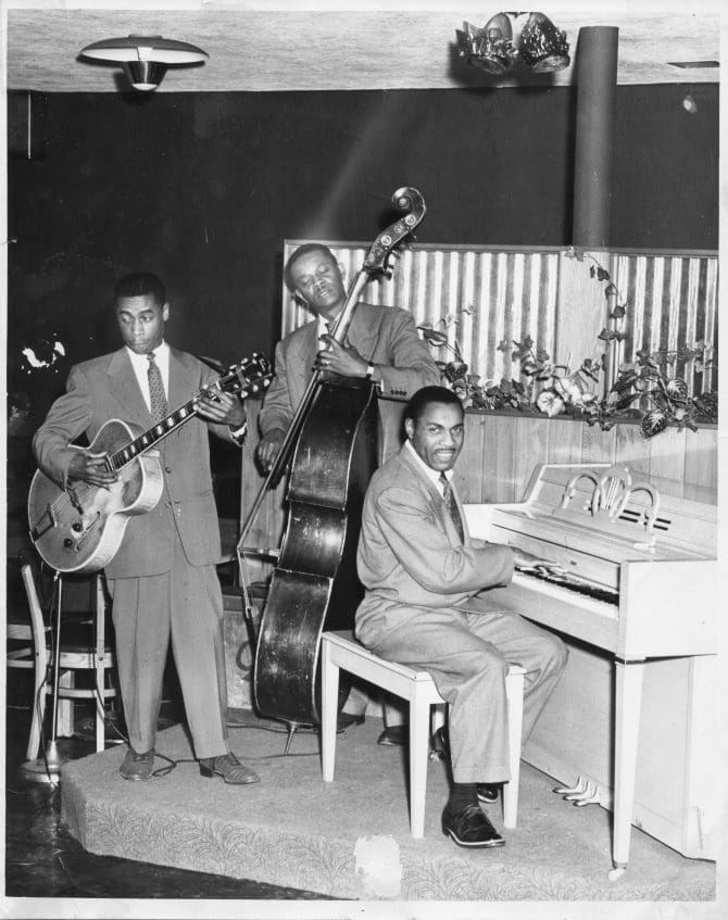Musicians Bob Lewis (bass), Norvell Randell (piano), Eric Miller (guitar)on stage at Slim Jenkins Bar and Restaurant Oakland, California