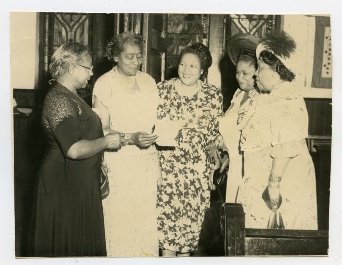 Reading a night letter from the Honorable Earl Warren, Governor of California, inviting the National Association of Colored Women's Clubs Convention to California (left-right): Margaret Nottage, Lillian M. Dixon, Gertrude Reese-Hicks, Mable Gray, Billie Ashby