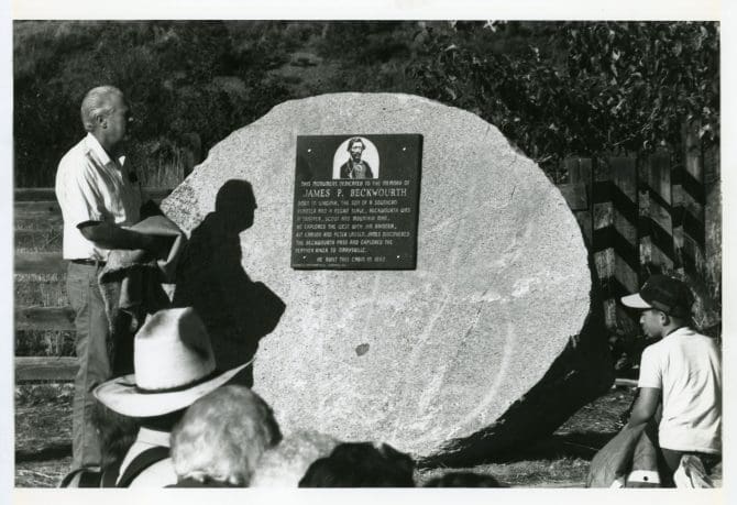 Man unveiling the James Beckwourth historical marker at the dedication of the James Beckwourth cabin museum