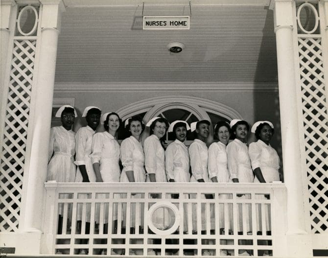 Fairmont Hospital nurses on porch below 'Nurses Home' sign