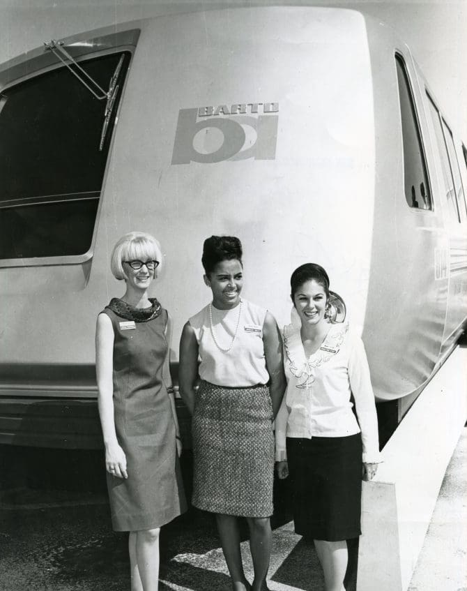 Carol Marshall, Barbara Kelly, and Carolyn Pini standing next to BART train circa 1960s