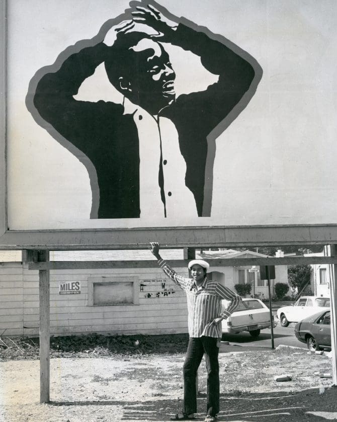 Cleveland Bellow standing until billboard with Untitled (Young Man) artwork