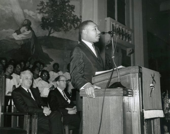Dr. Martin Luther King Jr. standing at the pulpit, 1964