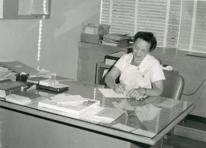 Elinor Watkins seated at desk