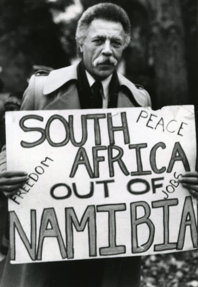 Congressmember Ronald Dellums holding up 'South Africa out of Namibia' protest sign undated