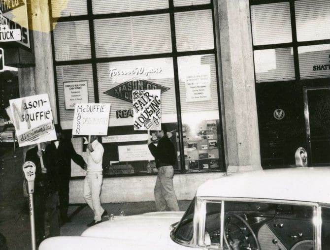 Protesters holding Mason-McDuffie fair housing placards outside the Mason McDuffie Realty Co. offices, circa 1960s