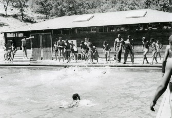 Carl Mack Sr. teaching boy scouts to swim at swimming pool at Los Nachos
