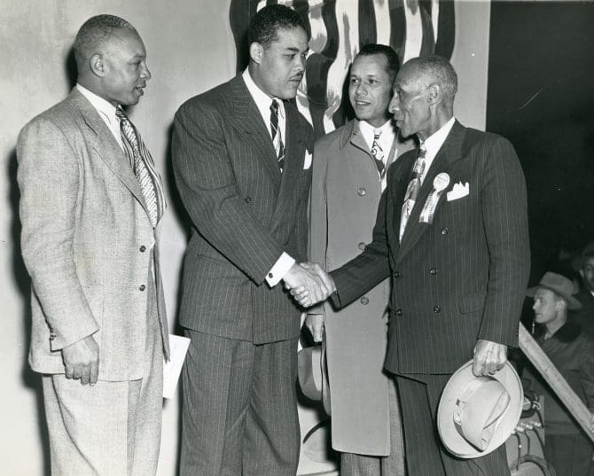 Boxer Joe Louis and Frederick M. Roberts shaking hands