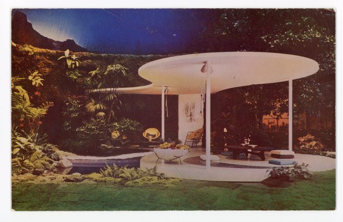 Color image of a backyard scene with a modernist patio surrounded by plants and overlooking a small pond.
