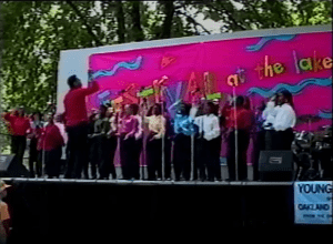 Image from a video of the Festival at the Lake's 1992 Young Artists Stage, showing teenagers singing and wearing in solid colored shirts and black pants..