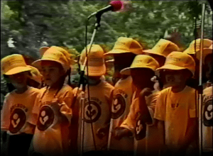 Image from a video of the Festival at the Lake's 1992 Young Artists Stage, showing children in matching yellow baseball caps and t-shirts.