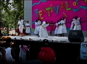 Image from a video of the Festival at the Lake's 1992 Young Artists Stage, showing teenagers dancing in matching white cotton dresses.
