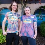 Two Library staff members show off their tie-dye Summer Learning shirts.