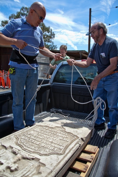 Jim, Ralph, and Tim retrieve Louis Pellier's tombstone from a History San Jose warehouse.