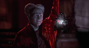Gary Oldman as Dracula, wearing a red robe and holding a lantern