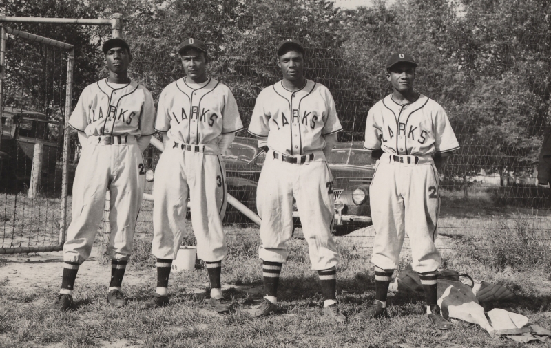 Four members of the Oakland Larks baseball team including San Jose State College graduate Johnny Allen (third from left). Photo Credit: H99.29.37. Unknown photographer, untitled (Oakland Larks of the West Coast Baseball Association), 1947. Gelatin silver photograph, 4 x 6 in. The Richard T. Dobbins Collection, Judith P. Dobbins. Collection of the Oakland Museum of California.