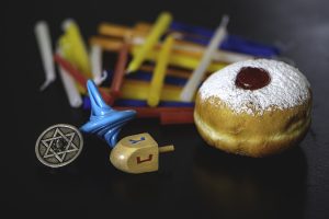 Jelly donut (also known as sufganiyot), dreidels, and candles for Hanukkah.