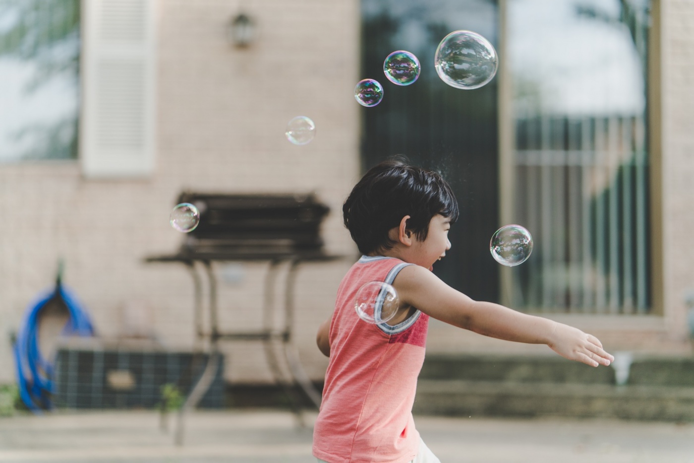 child playing with bubbles outdoors