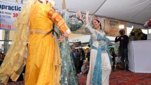women dancing in traditional dresses to celebrate Nowruz
