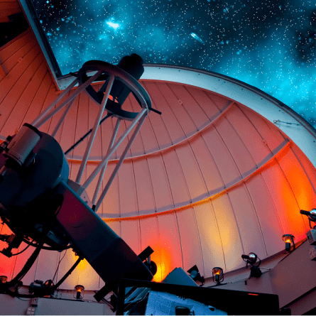 Telescopio gigante mirando hacia arriba, hacia un cielo lleno de estrellas.