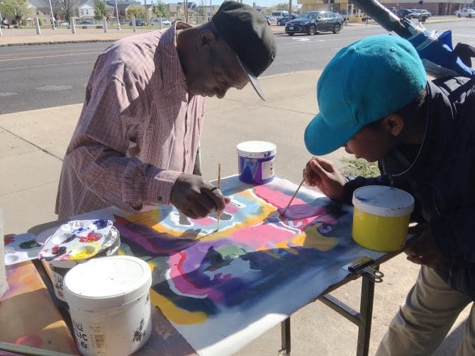 Neighborhood artists painting on the street.