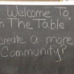 Chalkboard with text: Welcome to On the Table. How can we created a more unified community?