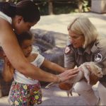 A zookeeper holds out a ferret for a young girl to touch, undated. Source: Special Collections, Chicago Park District Records: Photographs, Photo 167_010_005.