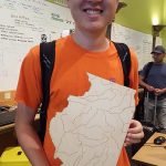 Man holding plywood in the shape of Illinois