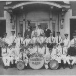 band members holding their instruments in front of a building