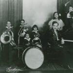 Dungill family, two adults, six children posing with musical instruments