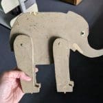 Wooden elephant painted gray with nicks and scratches from age and use.