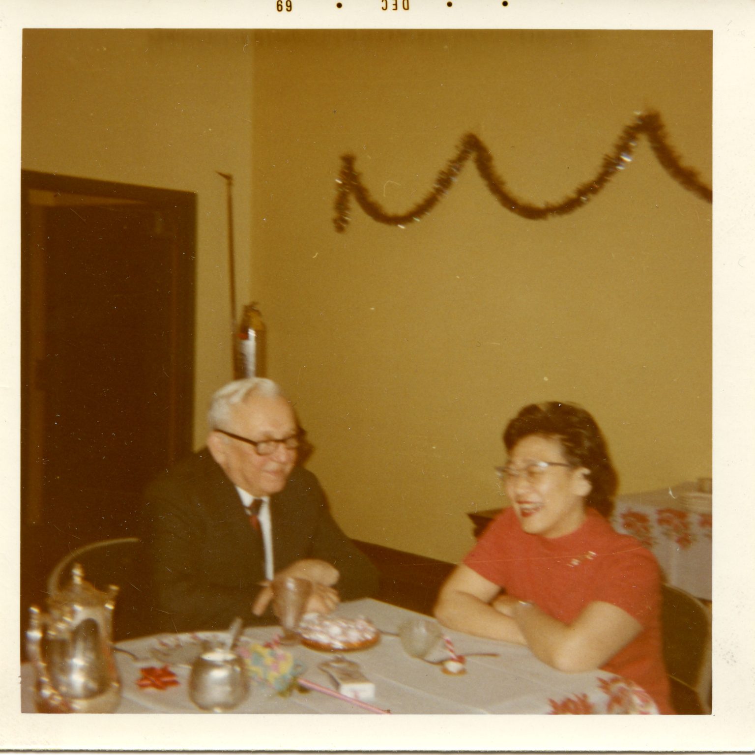 Alexander J. Skrzypek and Ruth Kumata sit at a table and talk during a staff gathering.