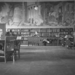 Hild Regional Library children's room, with person seated at desk in front of large mural