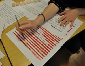 Photo of a person removing parts of a test to create an erasure poem