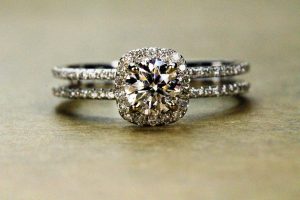 This image shows an engagement ring with a square cut, surrounded by tiny stones. The tiny stones and the large stone are so close together that they look like one big stone.