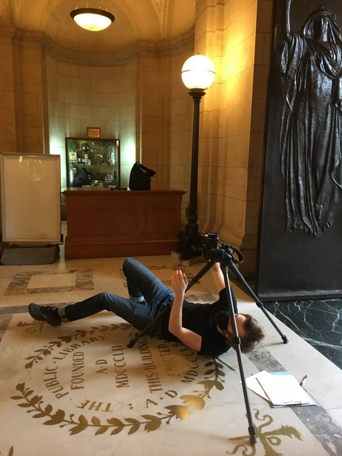 A member of BPL's A/V team films the Lobby ceiling from floor level.