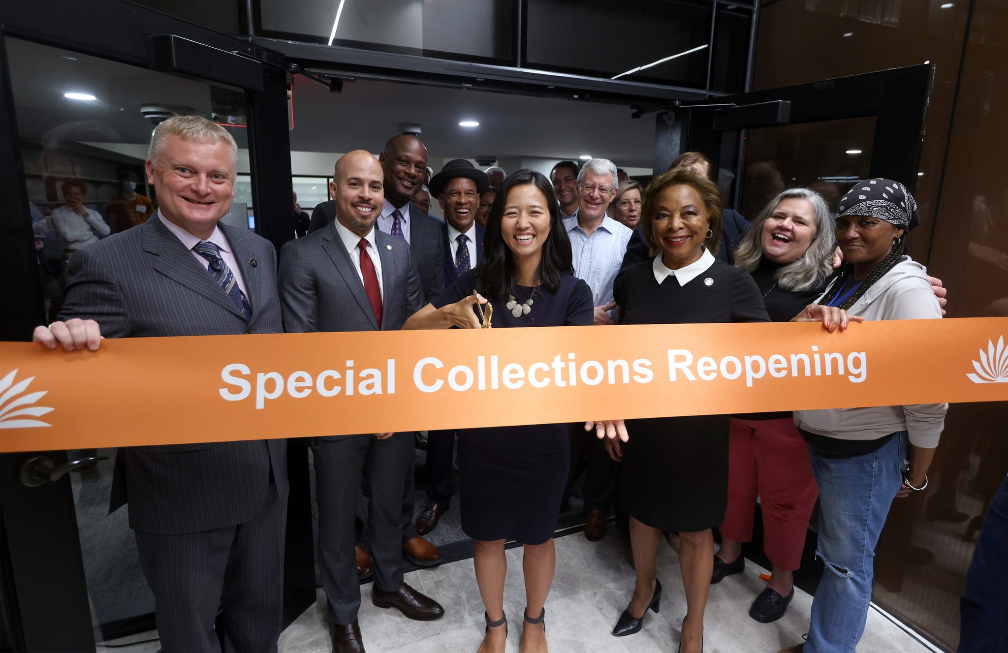 Mayor Michelle Wu cuts the orange Special Collections reopening ribbon