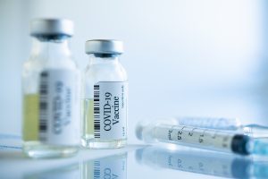 Doses of the COVID-19 vaccine with syringe